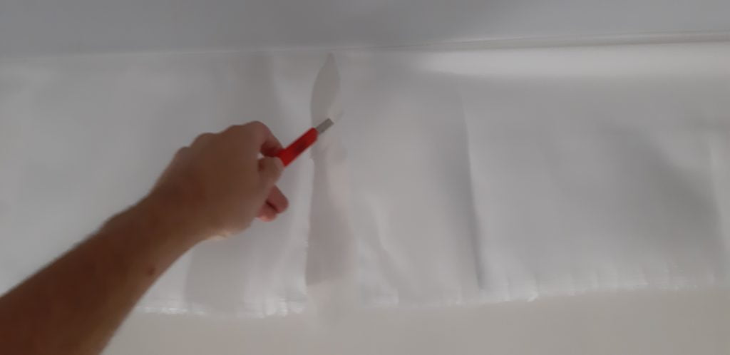 Обрізка тканини натяжної стелі